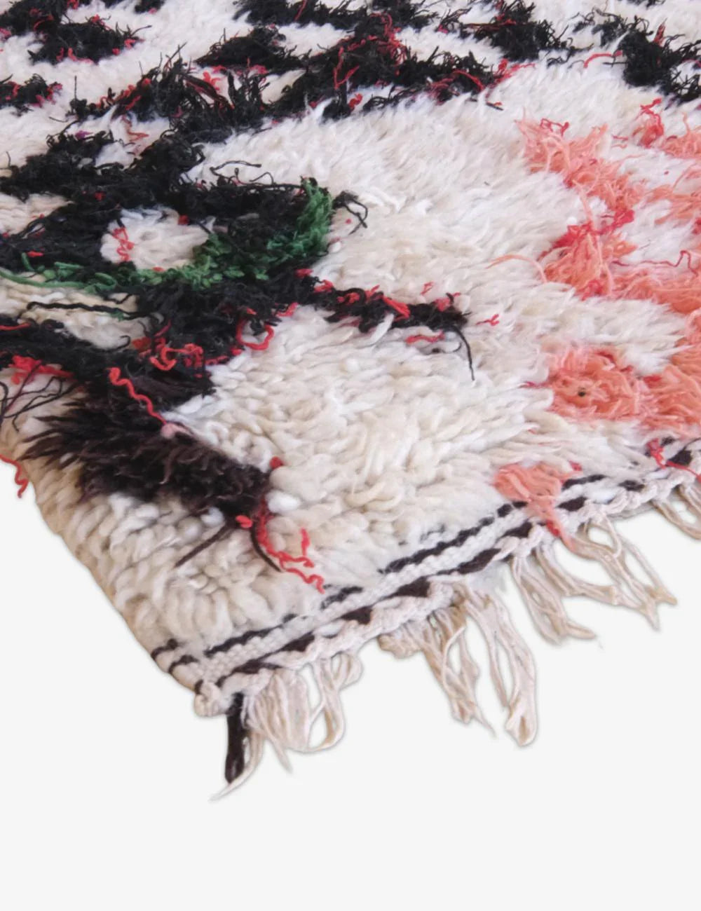 Close-up of a textured fabric with black, white, and pink patterns on a white background.