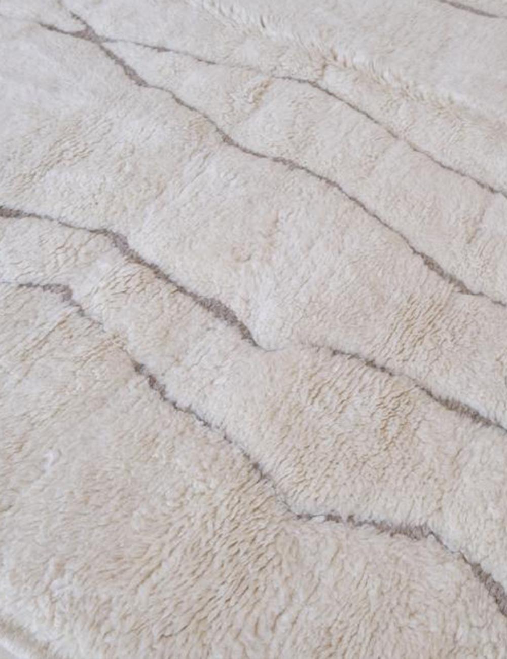 Contemporary Moroccan Beni Mrirt wool rug in beige with abstract irregular gray lines and thick soft pile.