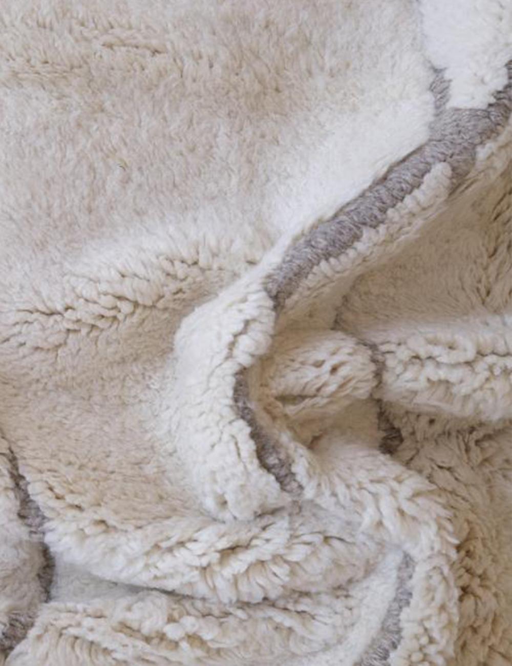Contemporary Moroccan Beni Mrirt wool rug in beige with subtle gray lines, showing thick soft pile texture.