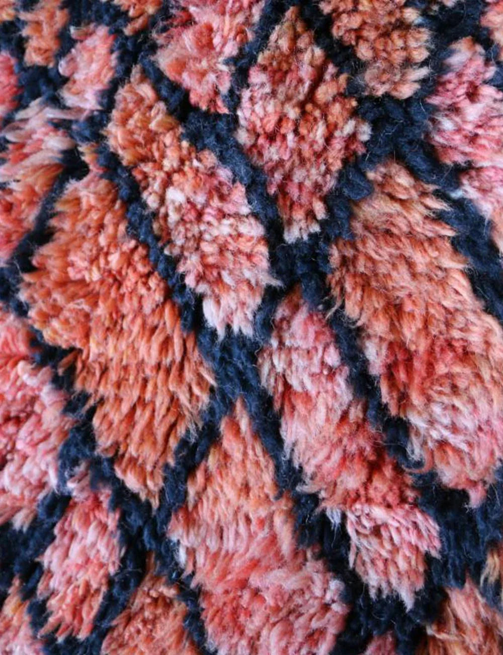 Close-up of the thick, plush wool texture of a pink M'rirt rug