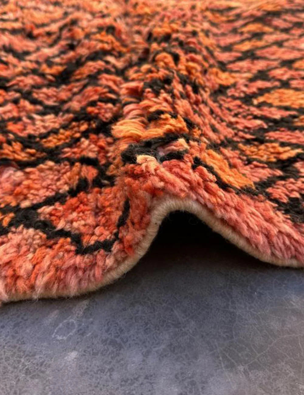 A detailed shot of the geometric black patterns on a pink Berber rug