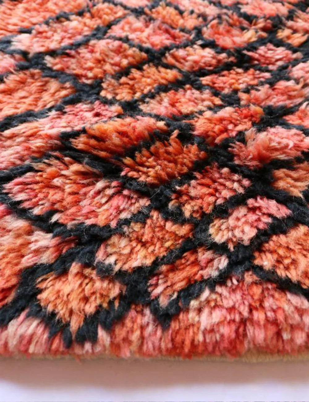 Close-up of a textured fabric with a geometric pattern in orange and black.