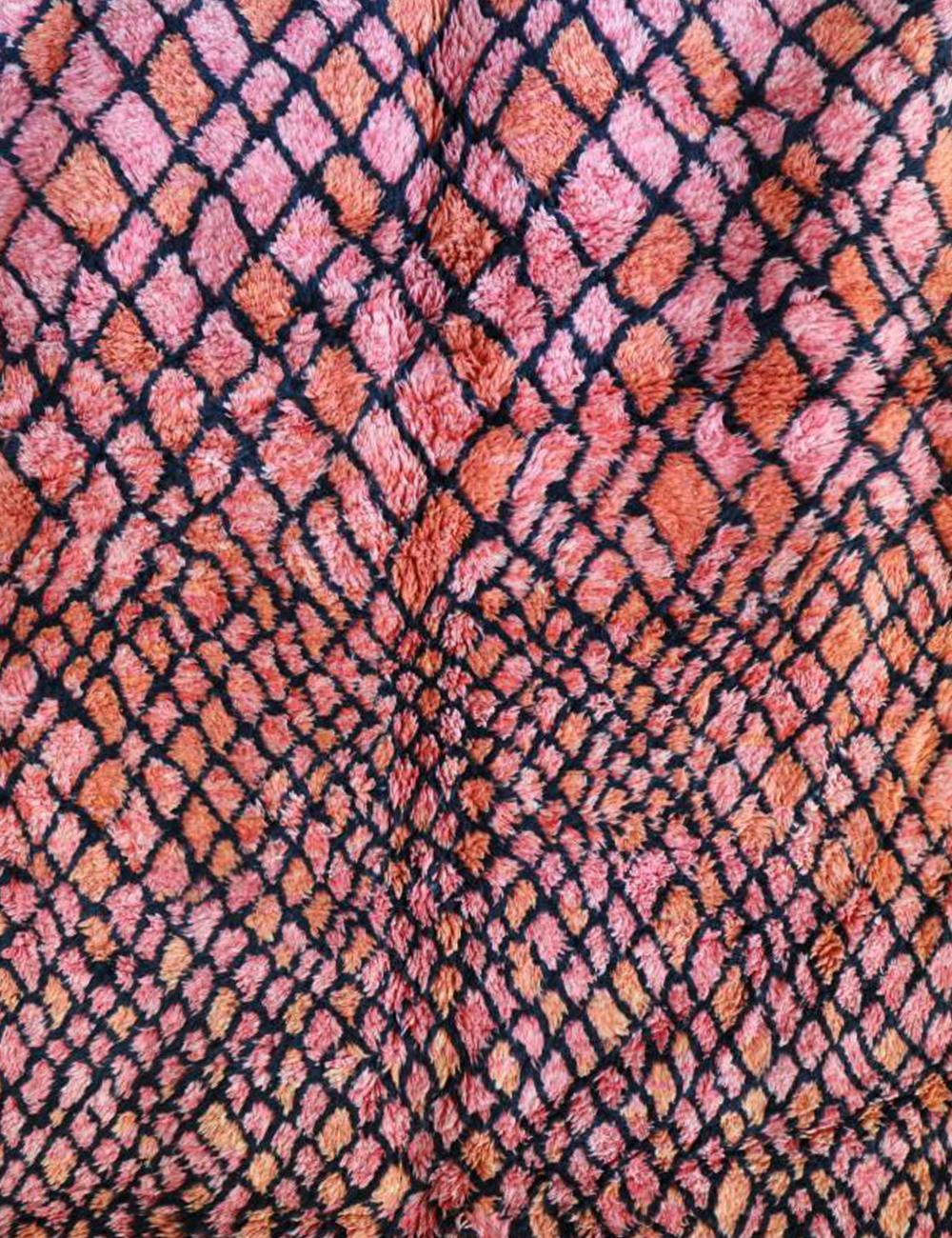 Close-up of a textured fabric with a pink and orange pattern