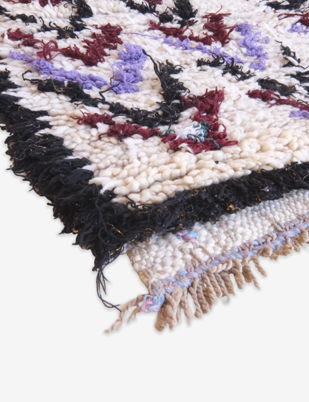 Close-up of a textured rug with multicolor pattern on a white background