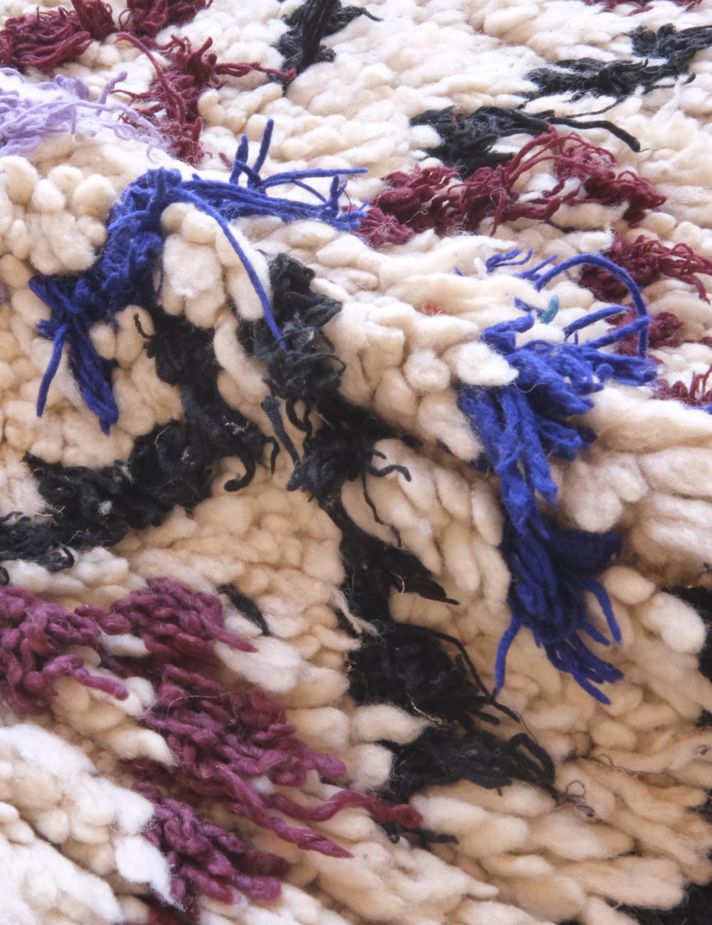 Close-up of a textured fabric with colorful yarn strands