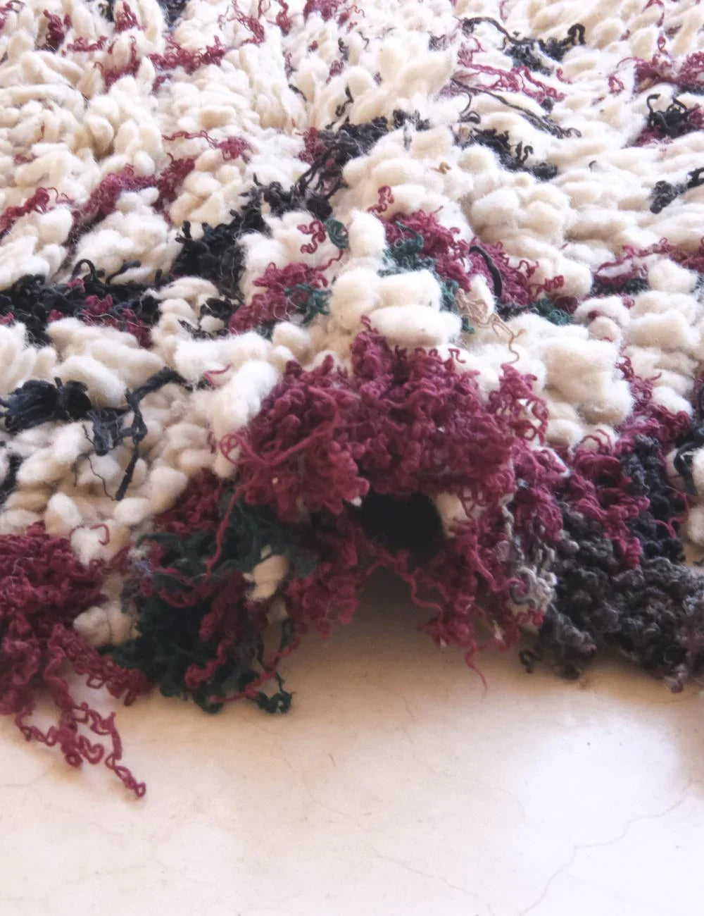 Close-up of a textured fabric with purple and black patterns on a white background