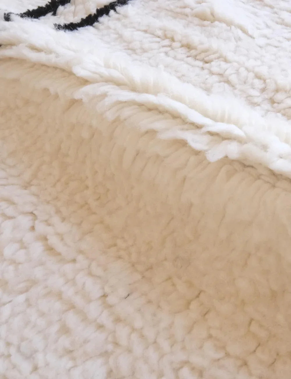Close-up shot of the thick wool pile of a hand-knotted Beni M'rirt rug