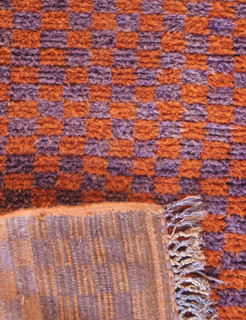Close-up of a checkered fabric with orange and purple pattern