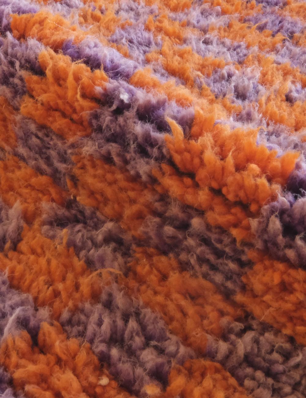 Close-up of a textured orange and purple fabric surface