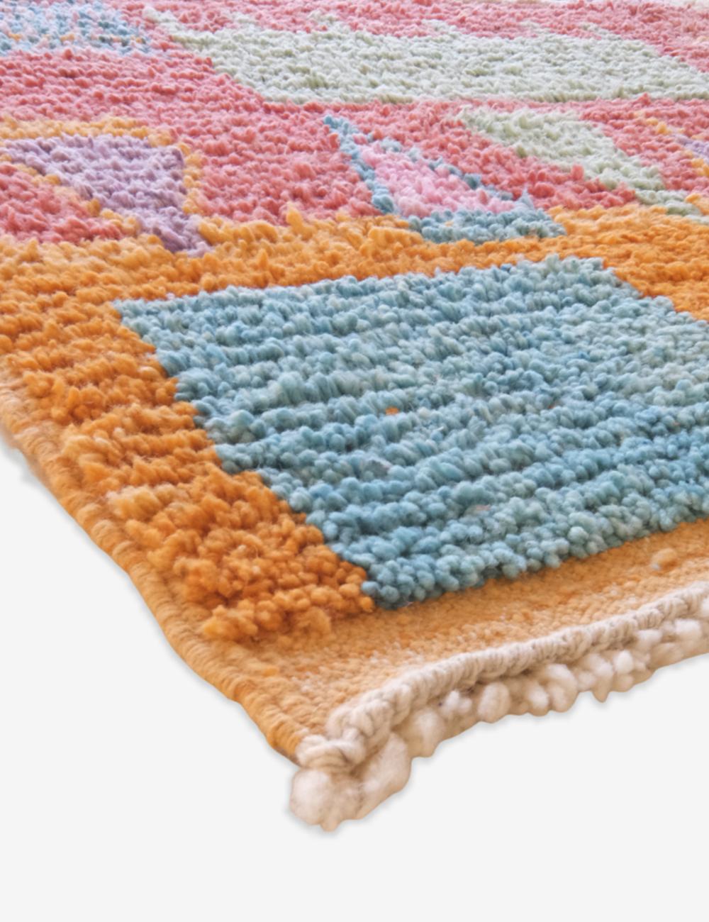 Colorful textured rug with geometric patterns on a white background