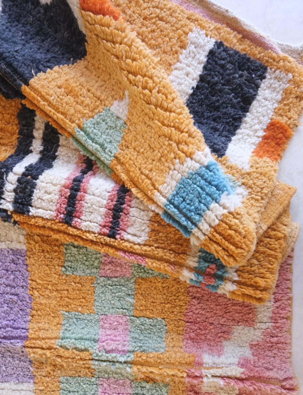 Stack of colorful textured fabric swatches on a white background
