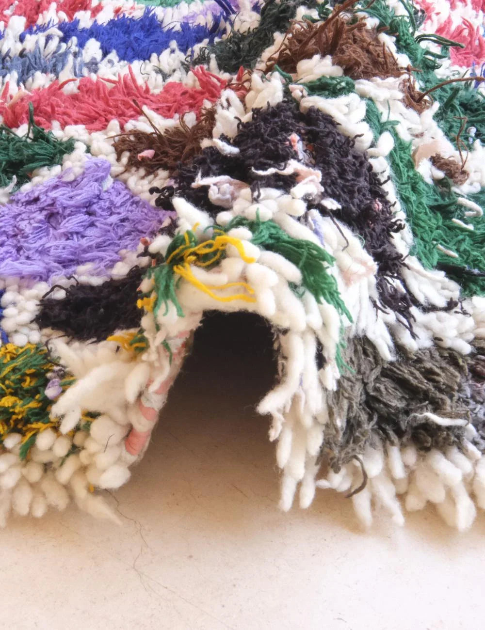 Colorful knitted or crocheted animal figure with a textured surface.