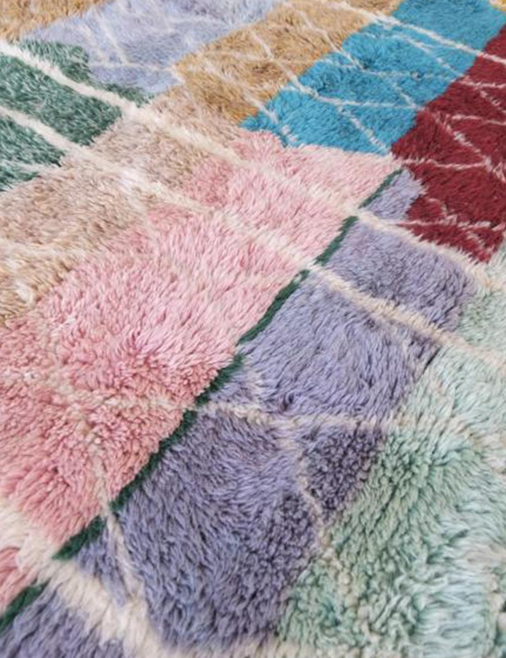 Contemporary Moroccan Beni Mrirt wool rug with soft pile and multicolor geometric squares in pink, purple, green, blue, and burgundy tones.