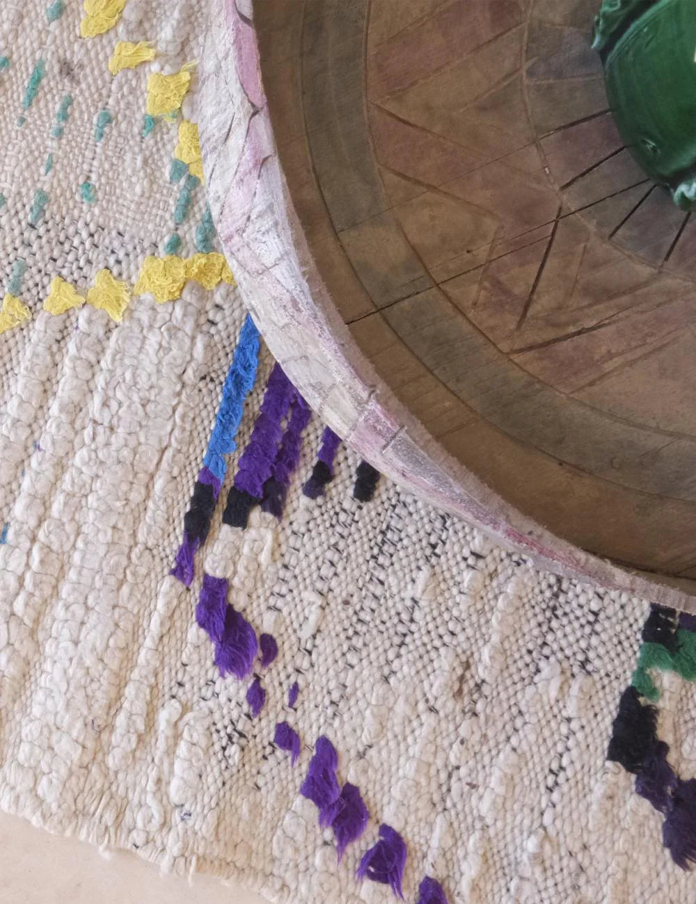 Close-up of a textured surface with colorful patterns and a wooden object.