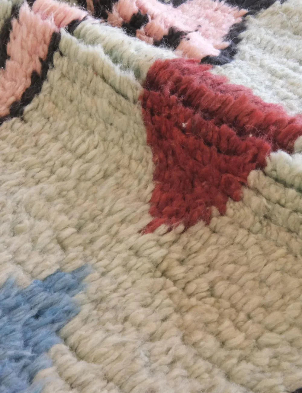Close-up of a textured rug with colorful star patterns