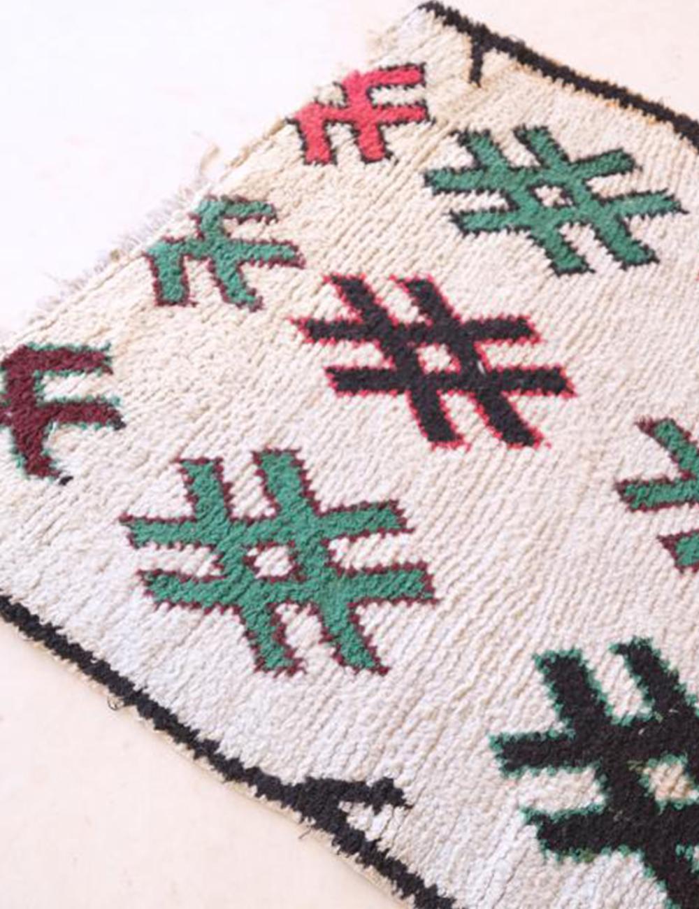 Close-up of a woven textile with geometric patterns on a white background
