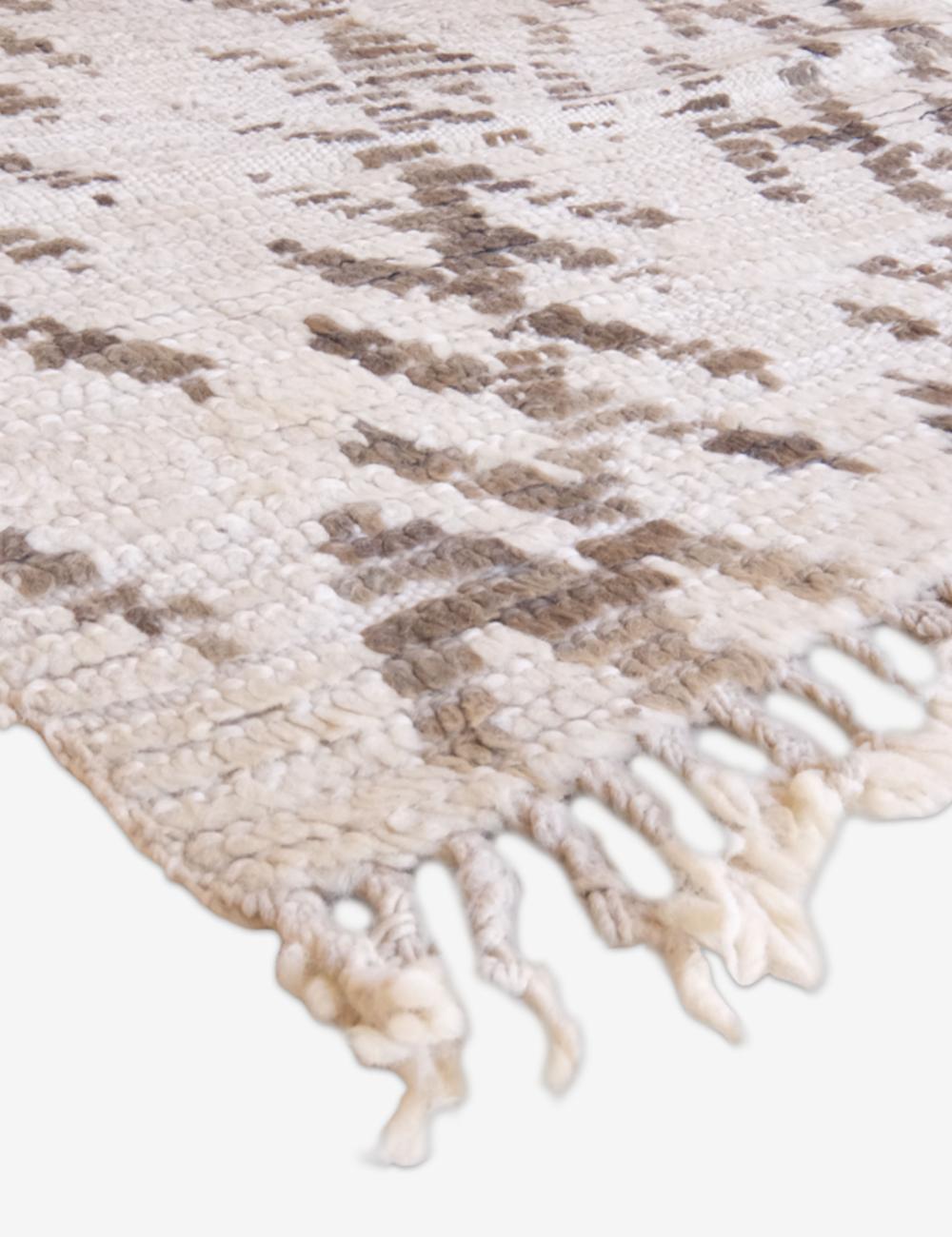 Textured area rug with a pattern and tassels on a white background