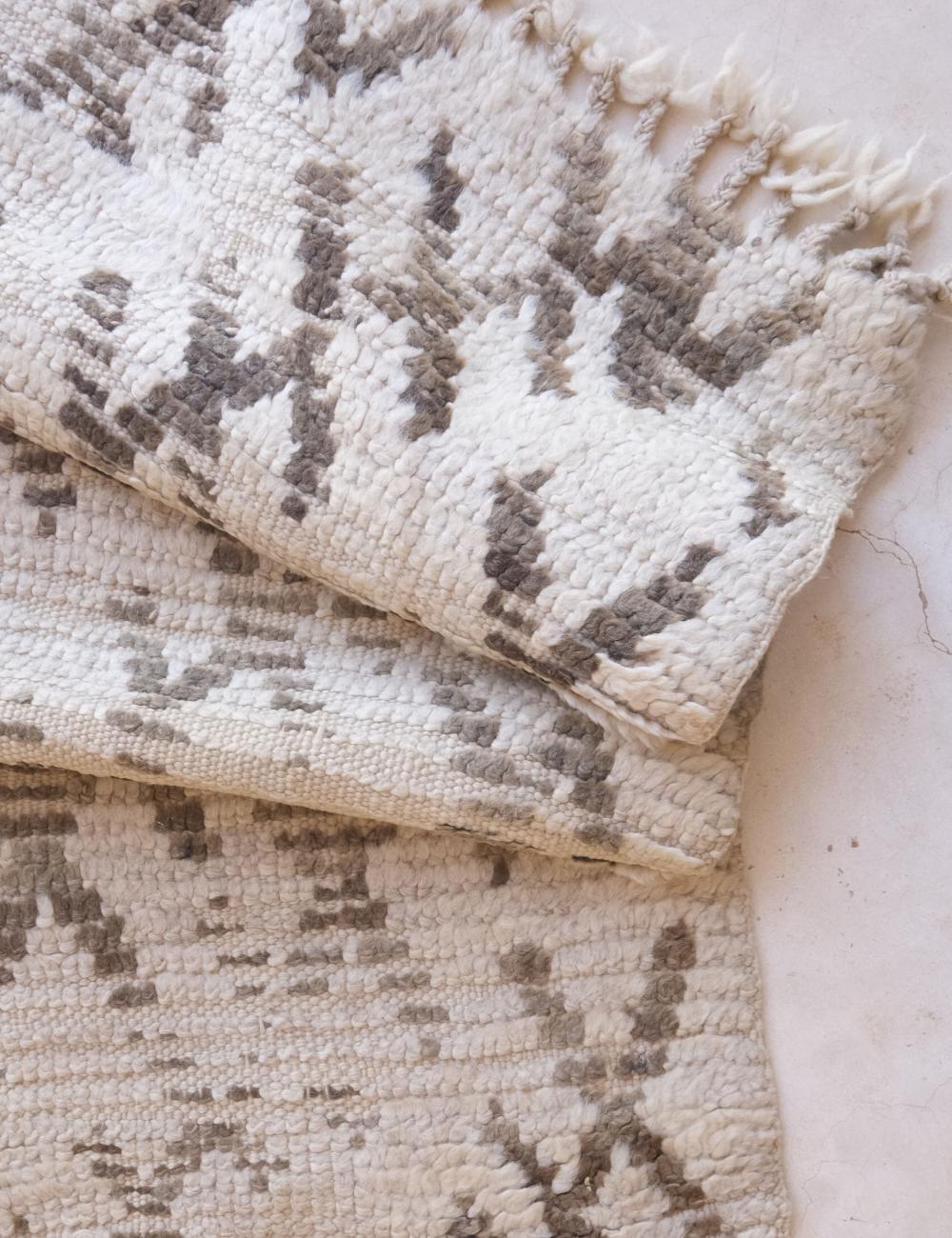 Textured beige and brown patterned rug on a light background