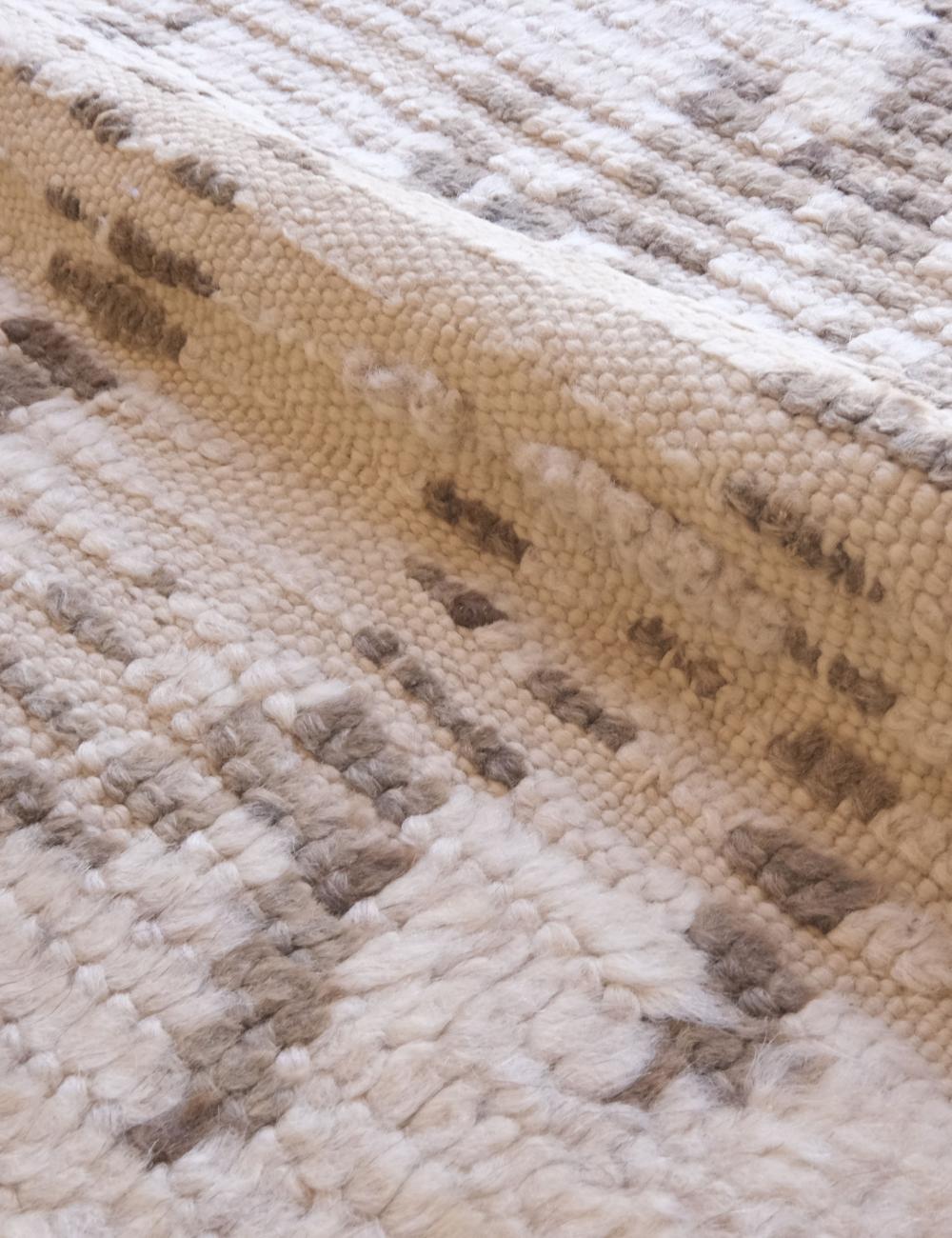Close-up of a textured beige and brown rug with a diamond pattern.