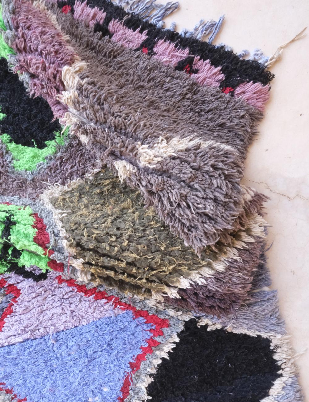 Close-up of a textured, multicolored fabric with a focus on a green square.