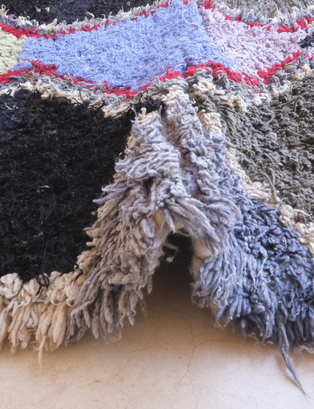 Close-up of textured fabric with multicolor pattern on a neutral background
