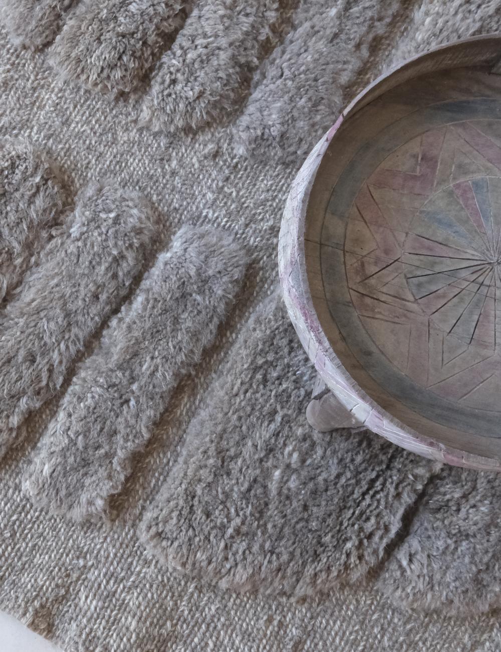 Wooden bowl with geometric patterns on a textured surface