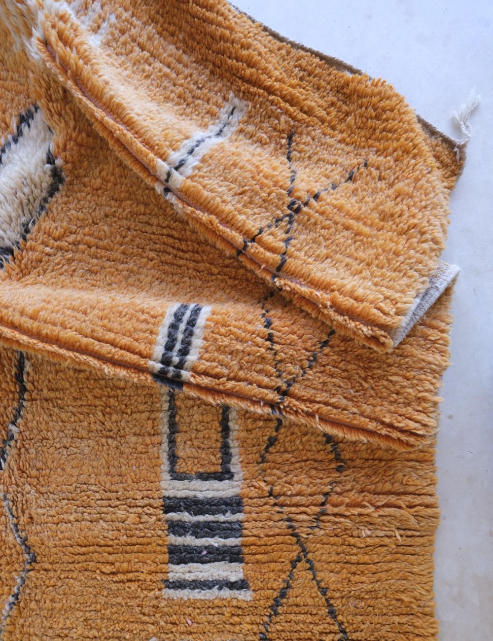Brown textured rug with geometric pattern on a light background