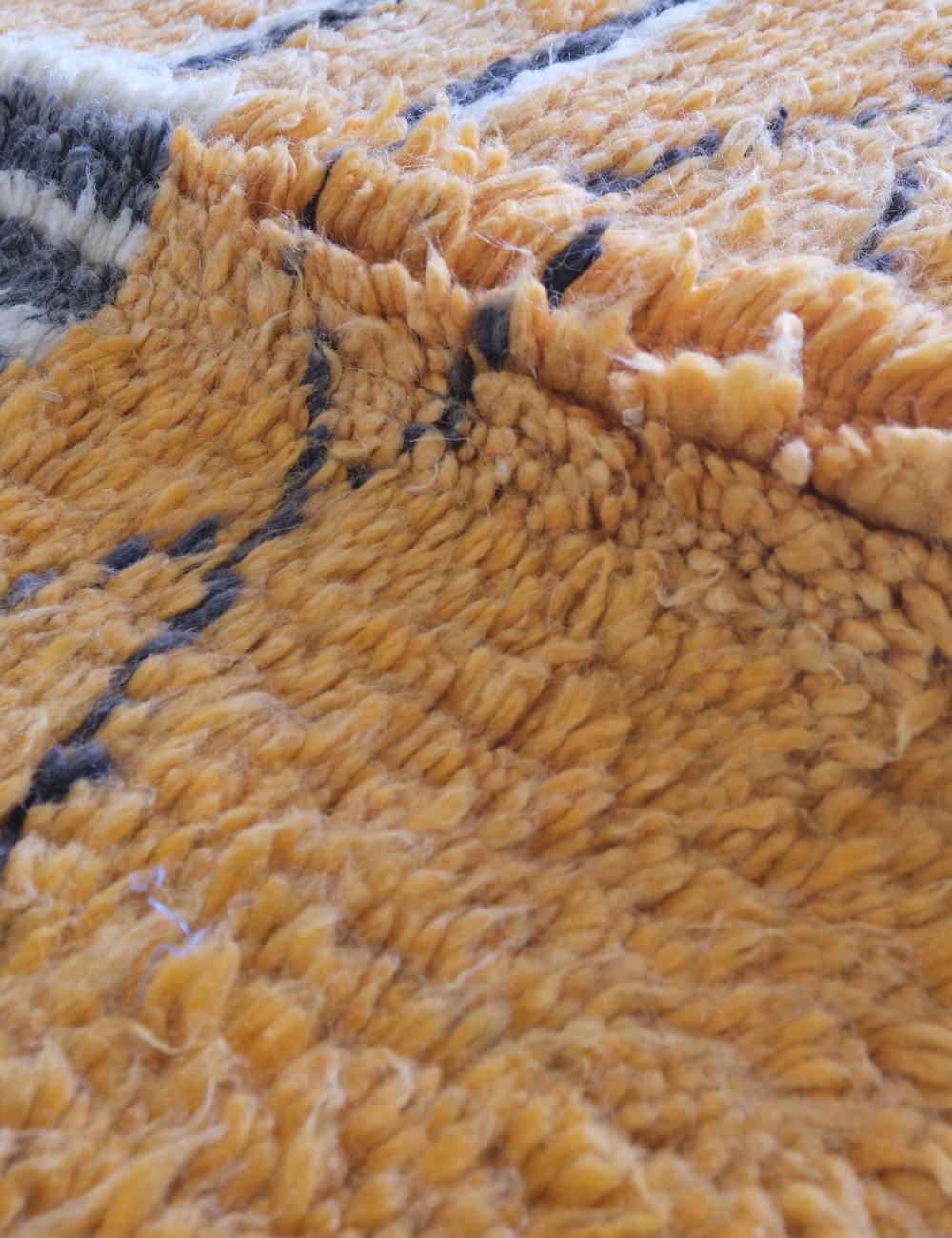 Close-up of a textured yellow fabric with black and white patterns