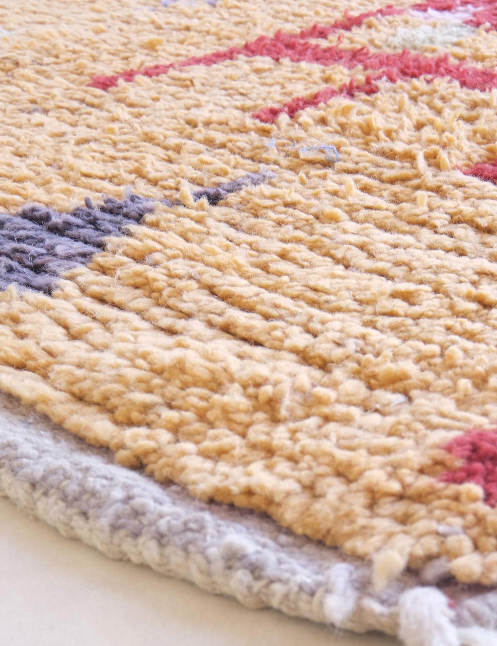 Close-up of a textured rug with geometric pattern on a light background