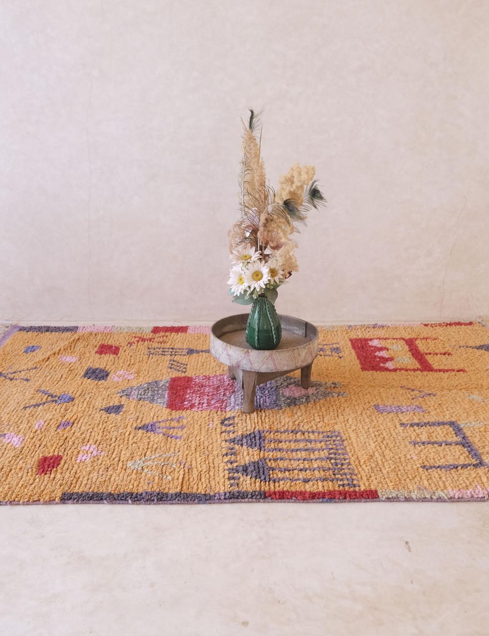 Decorative rug with a table and floral arrangement on a light background