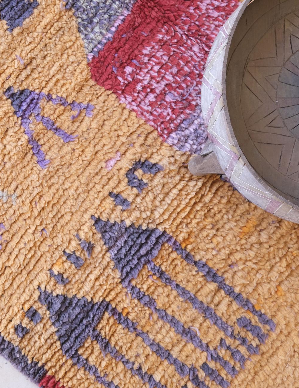 Close-up of a textured rug with geometric patterns and a woven basket.
