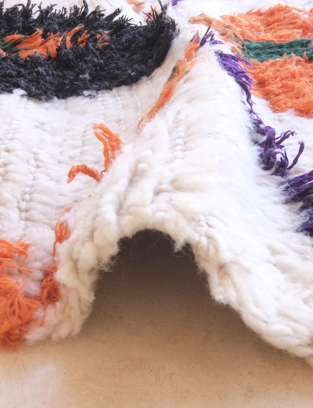Close-up of a textured fabric with multicolor yarns on a neutral background