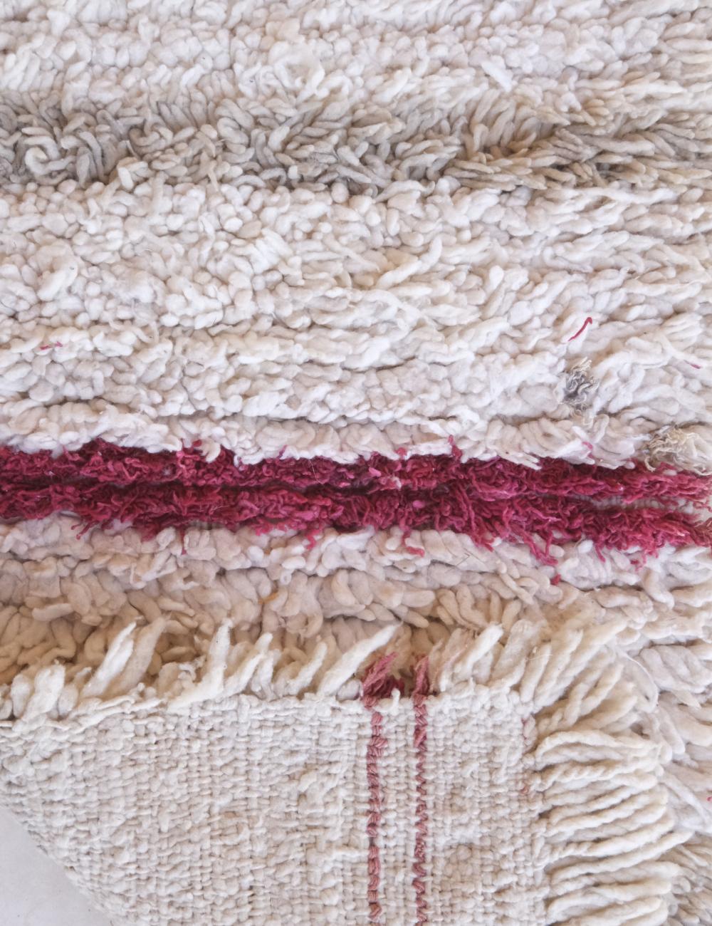 Close-up of a textured fabric with a red stripe