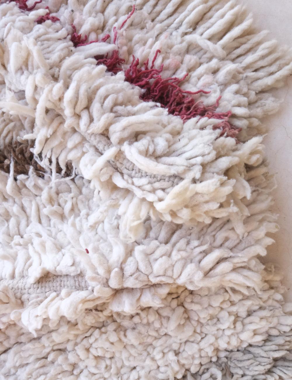 Close-up of a white mop head with red fibers on a white background