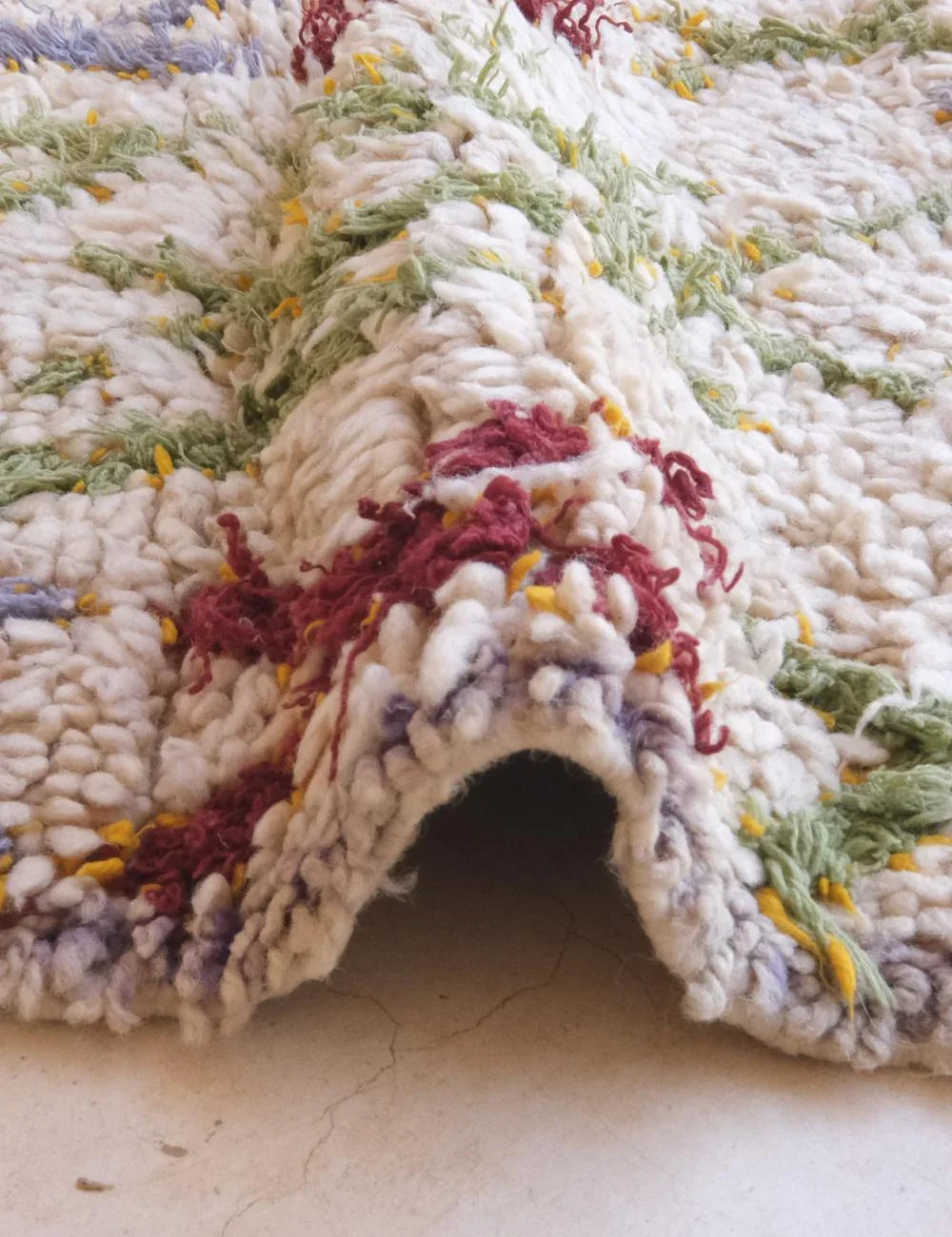 Close-up of a textured rug with multicolor pattern on a light background
