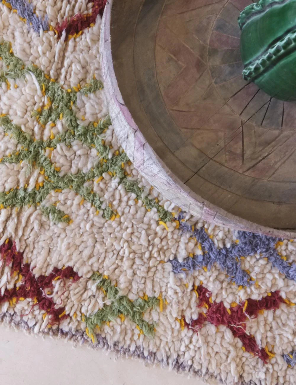 Close-up of a textured surface with colorful patterns and a wooden object.