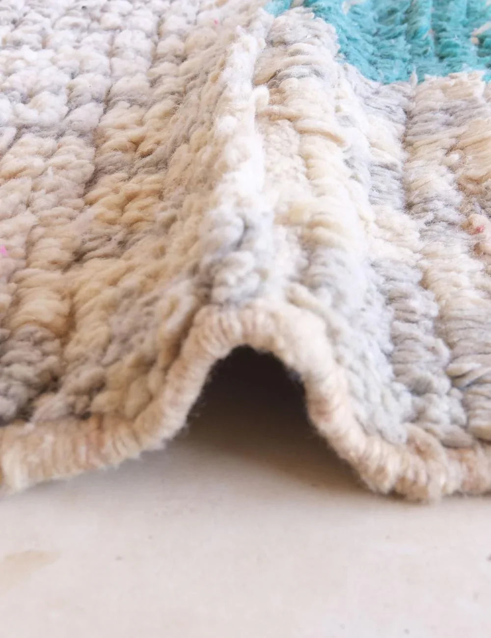 Close-up of a textured rug with a neutral color palette.