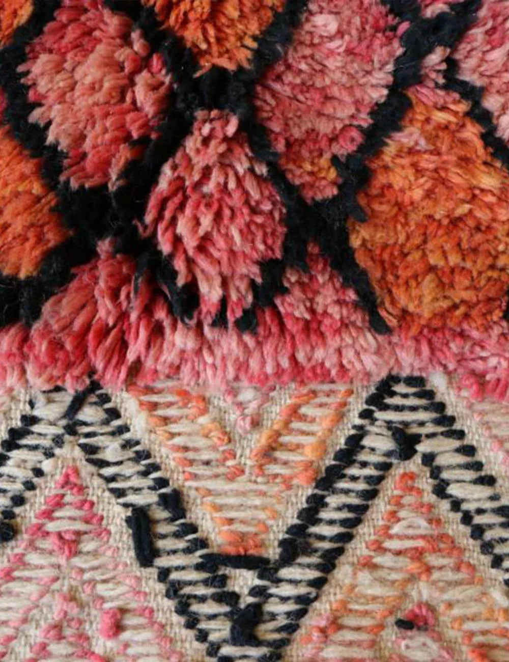 Close-up of a textured fabric with pink, orange, and black patterns