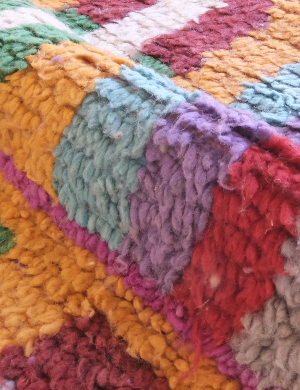 Close-up of a colorful textured fabric with a geometric pattern.