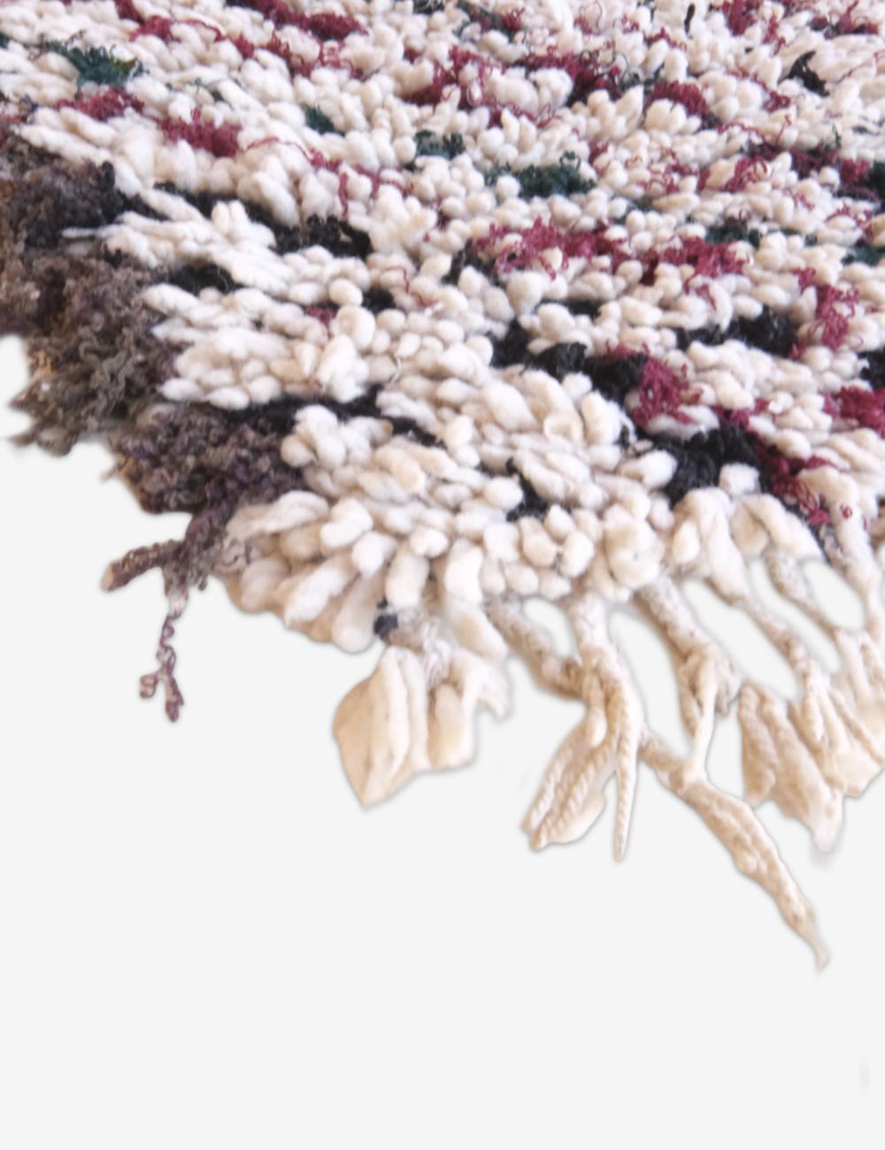 Close-up of a textured rug with multicolor pattern on a white background