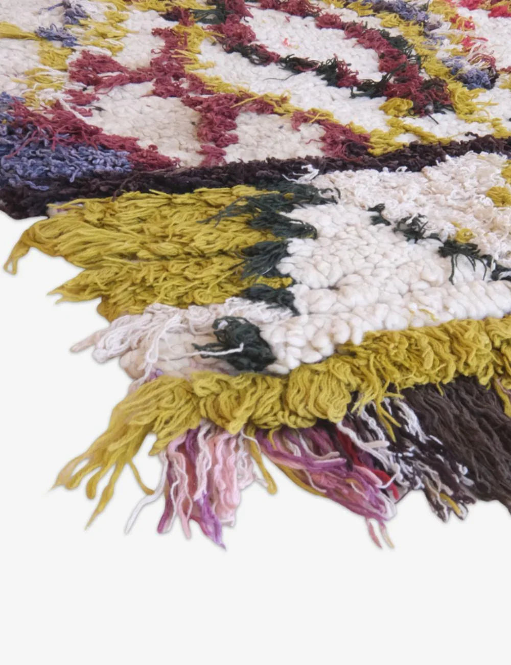 Close-up of colorful textured fabric with fringes on a white background