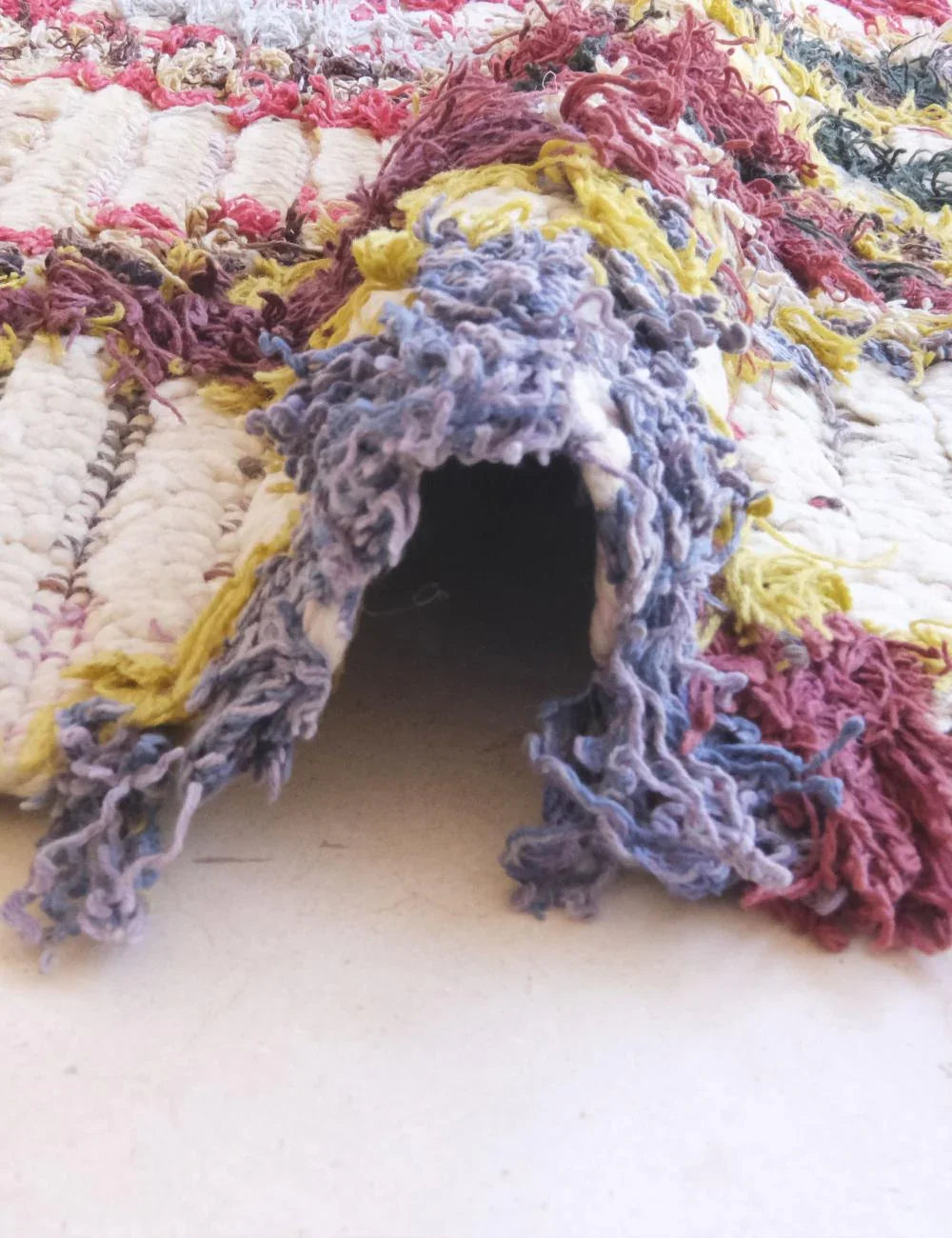 Close-up of a textured, multicolored fabric with frayed edges.