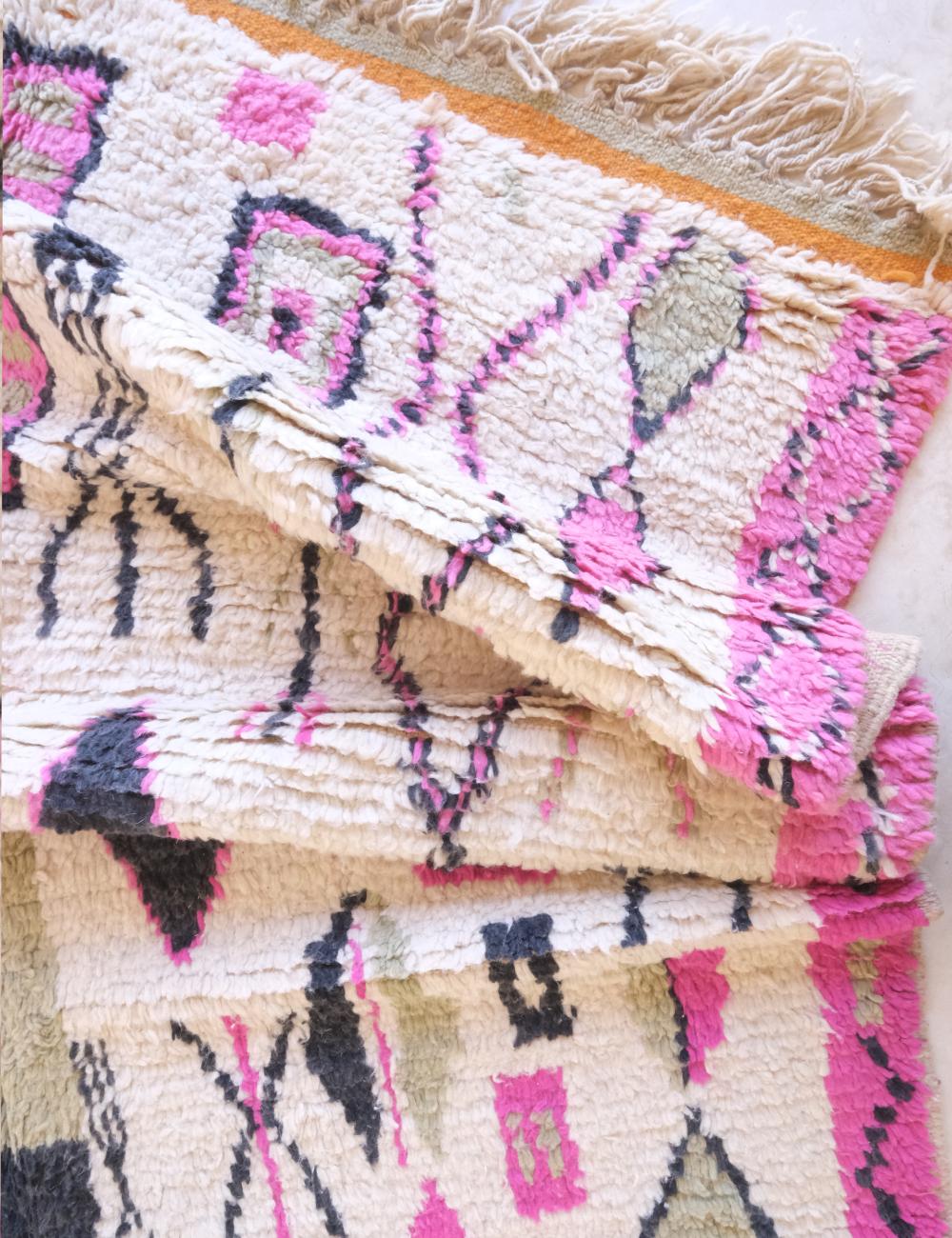 Close-up of a patterned fabric with pink, black, and beige colors.