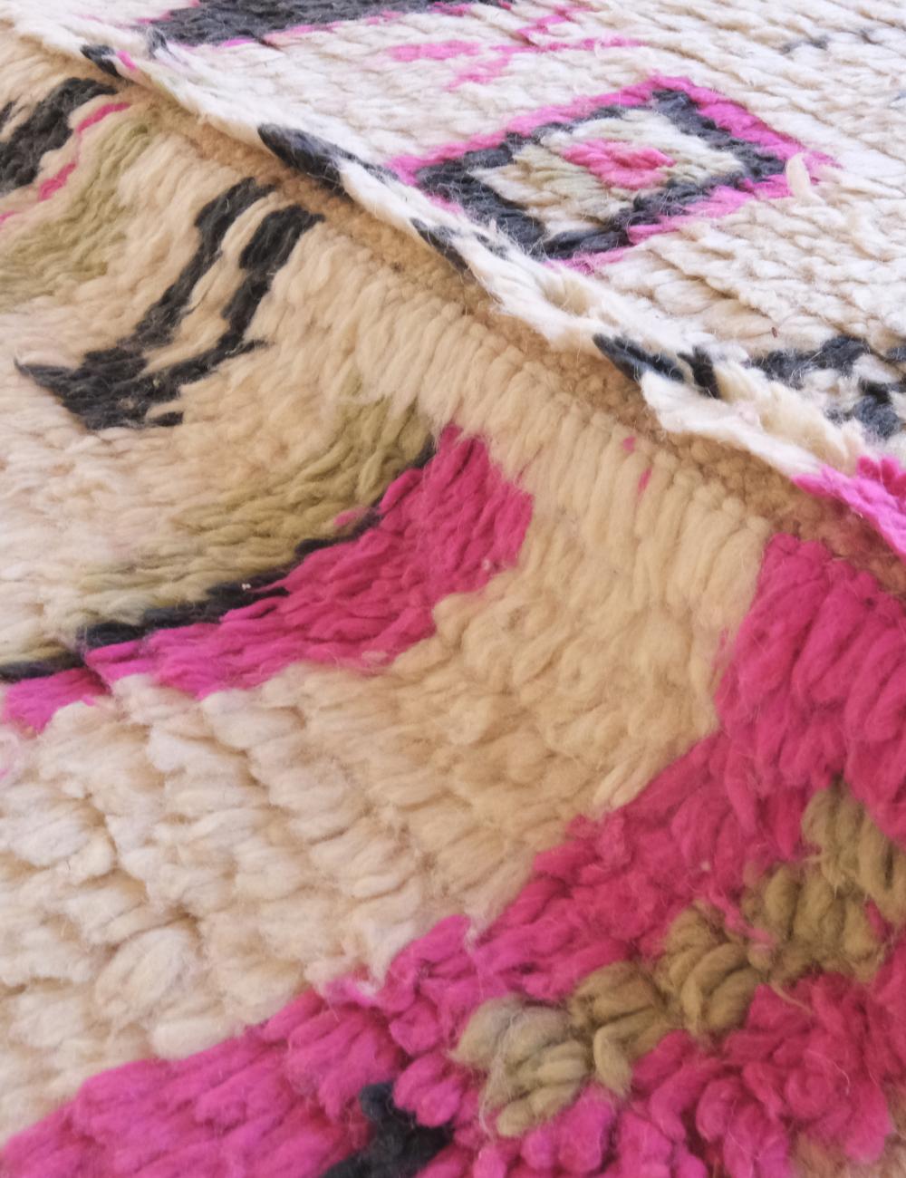 Close-up of a textured fabric with pink, beige, and black patterns