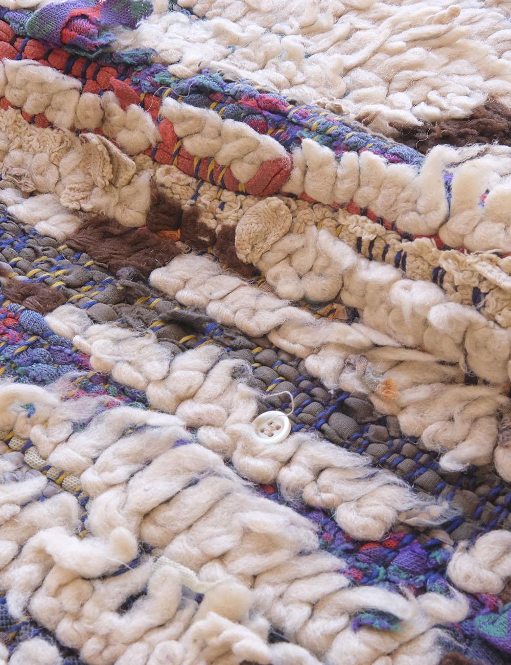 Close-up of a textured woven rug with multicolor pattern
