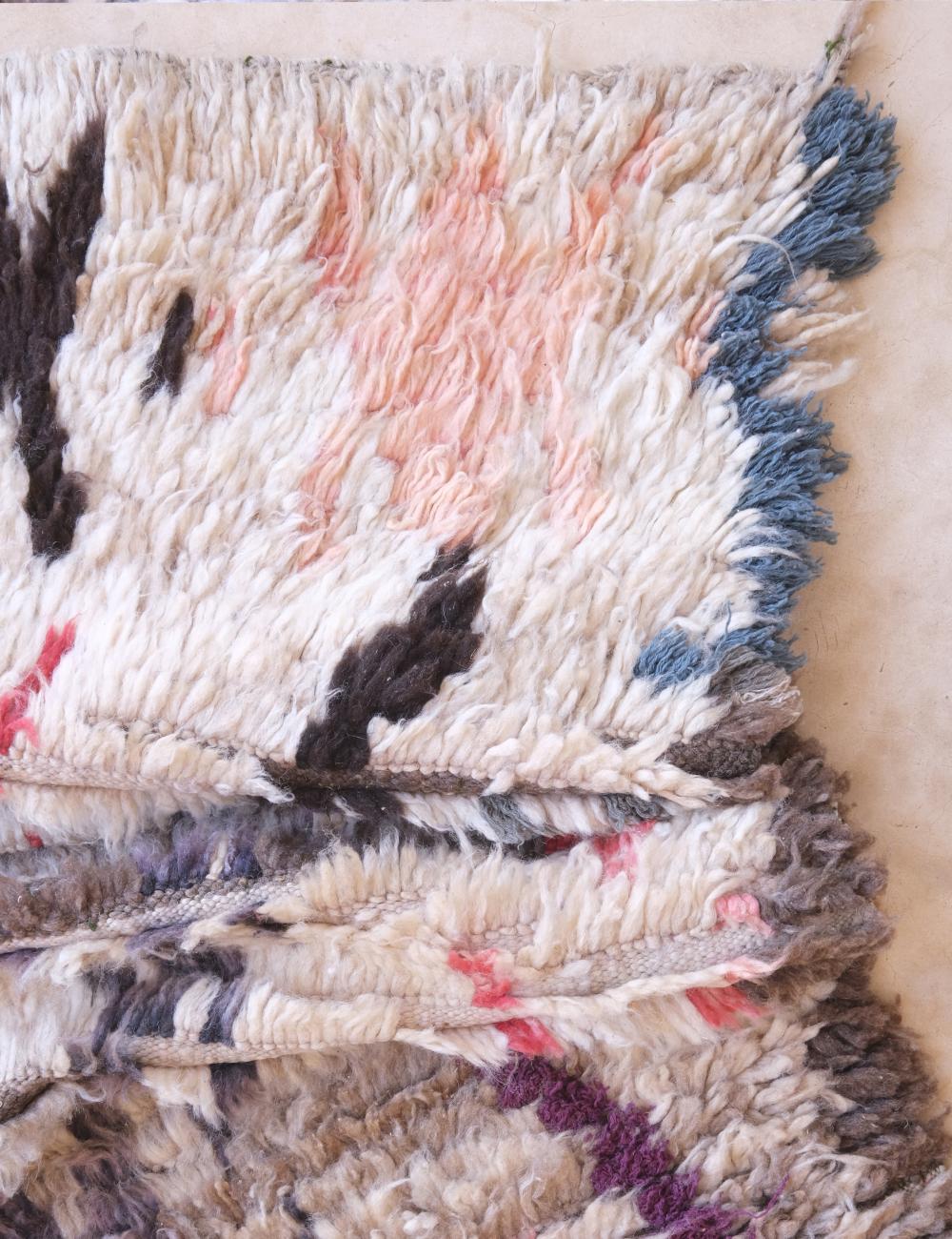 Close-up of a textured fabric with multicolor patterns on a beige background
