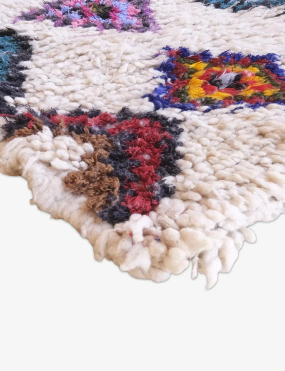 Close-up of a colorful woven rug with geometric pattern on a white background