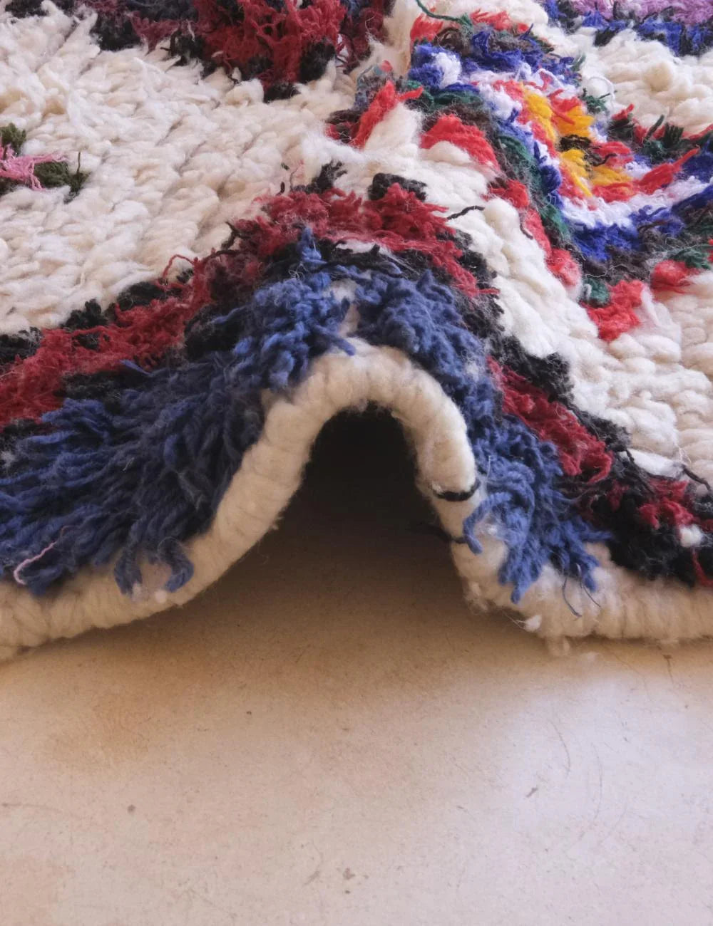 Close-up of a textured fabric with multicolor pattern on a neutral background