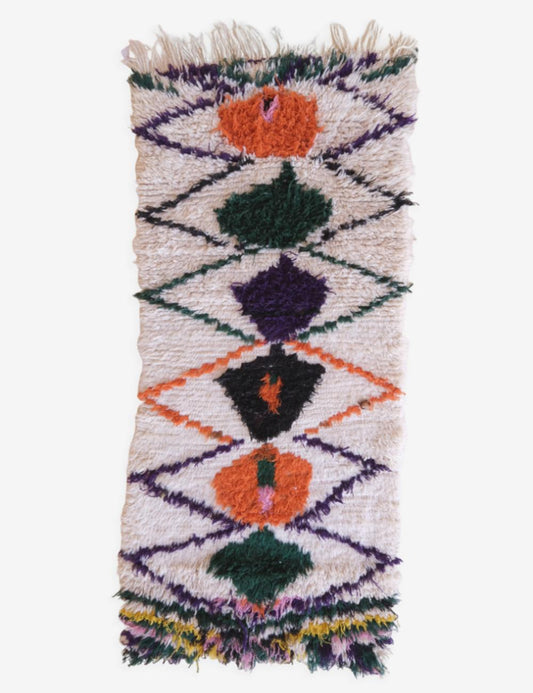 Small woven rug with geometric pattern on a white background