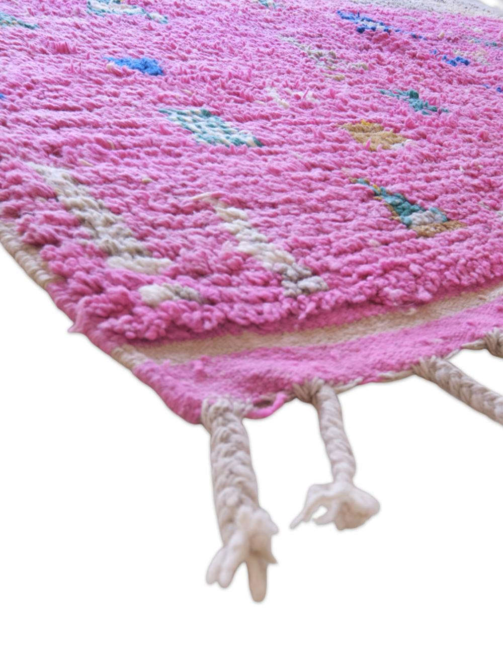Pink textured rug with colorful patterns on a white background